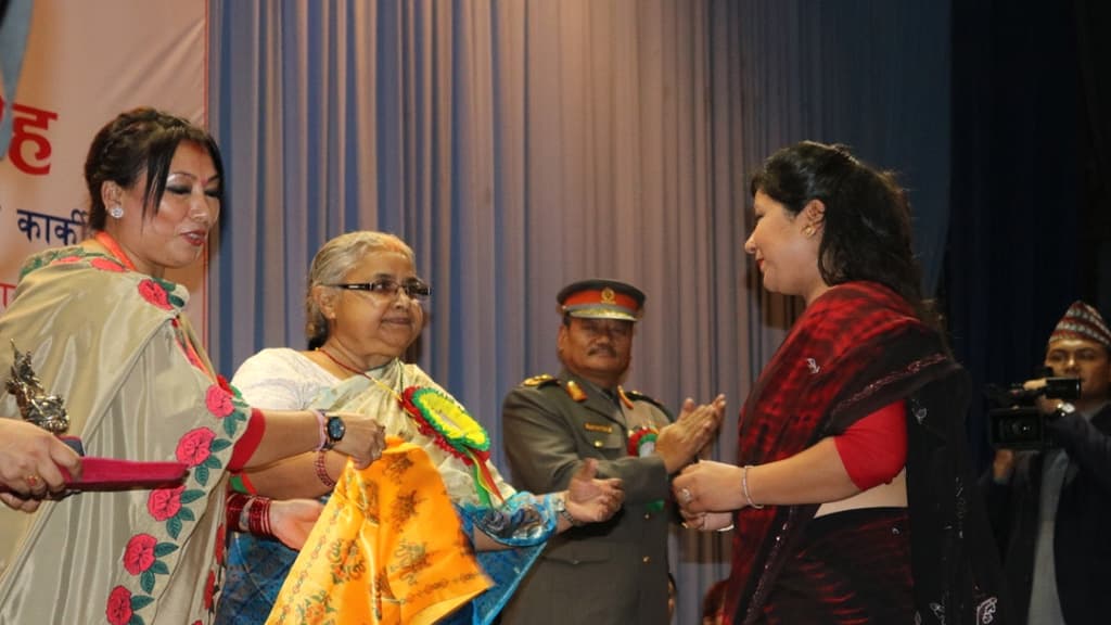Kalpana Rai receiving an award on stage from Chief Justice Sushila Karki.